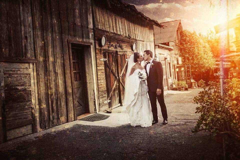 Couple kissing by rustic building