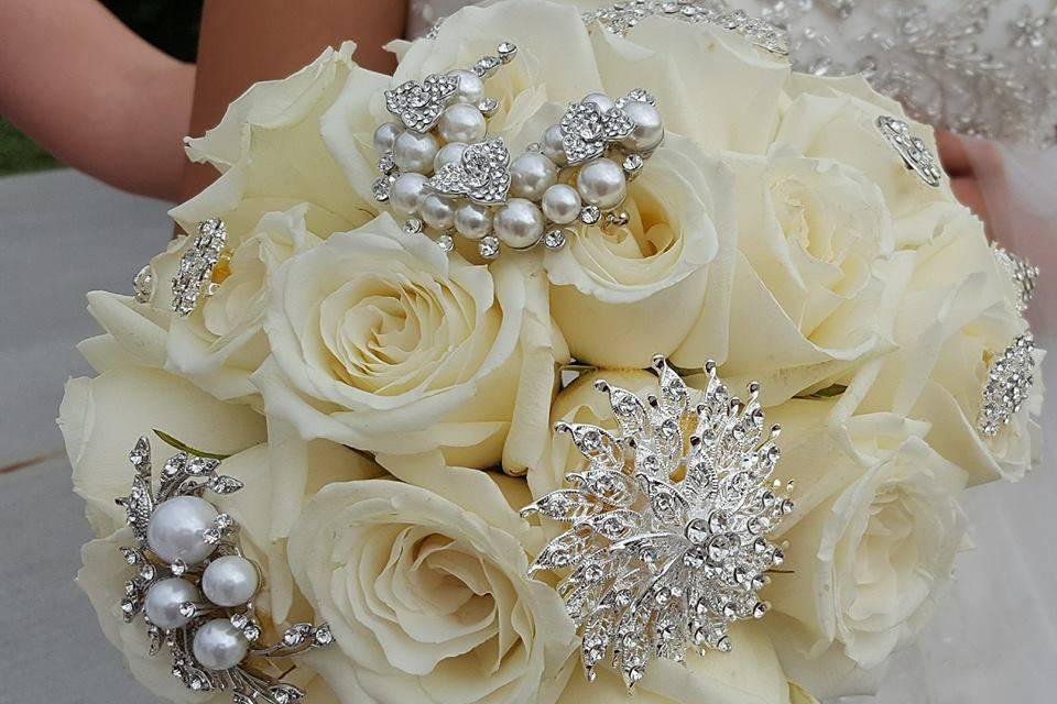 Cream roses with various types of brooches