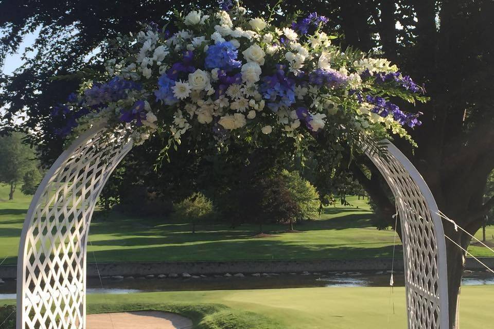 Blue and white flower arrangement on wedding arch