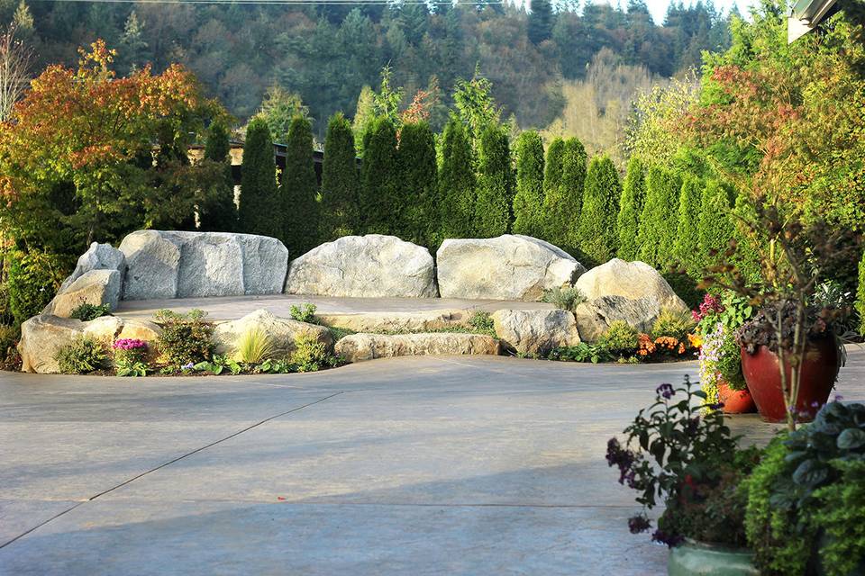 A beautiful natural granite rock stage is a focal point for ceremonies, with a large surrounding patio and lawn.