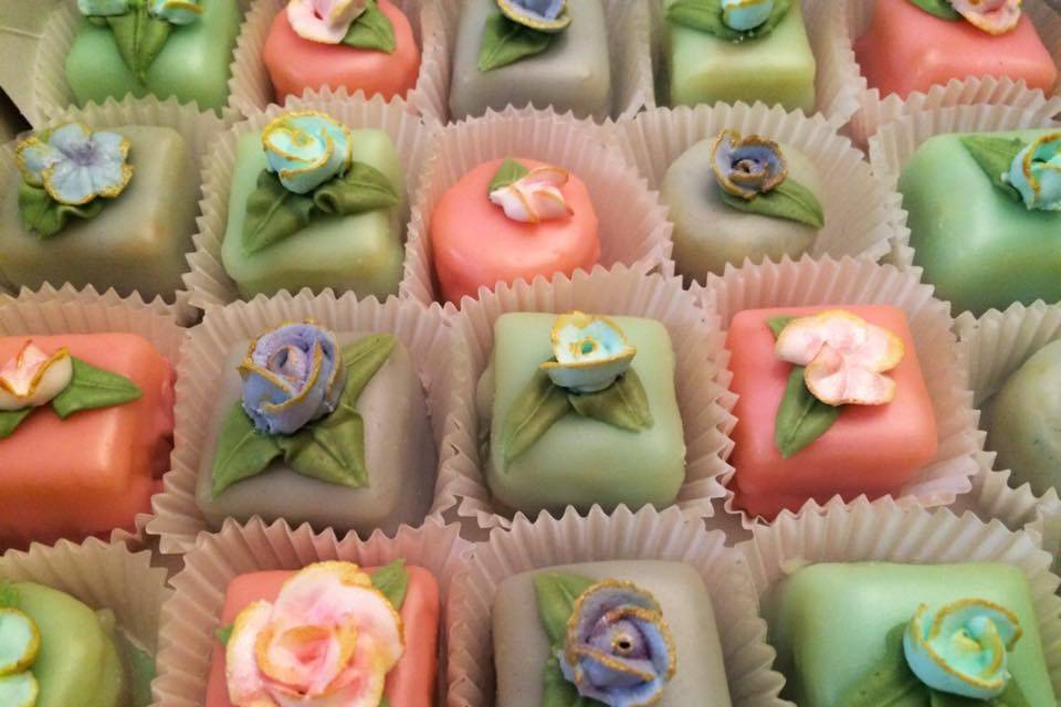 Vanilla petit fours with raspberry filling and pastel flowers