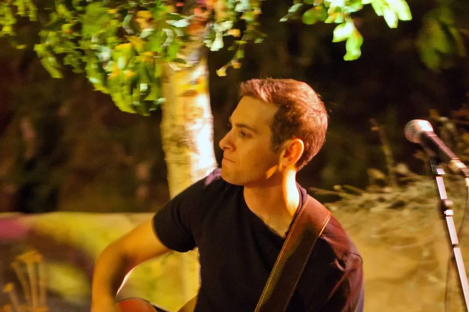 Aaron Goldfarb performing acoustic guitar at Ardivinos Desert Crossing
