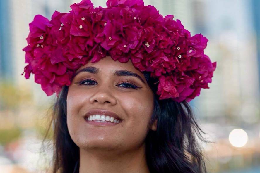 Smiling and wearing a floral crown