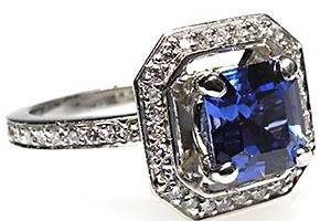 This eye catching natural blue sapphire and diamond engagement ring features the popular halo style mounting with micro pave diamonds and is crafted of solid platinum.