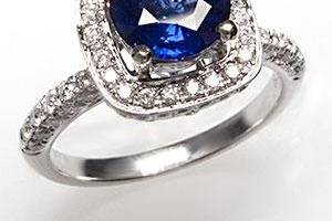 This magnificent natural blue sapphire engagement ring is crafted of solid 18k white gold and features a high quality center stone and a halo of genuine diamonds.