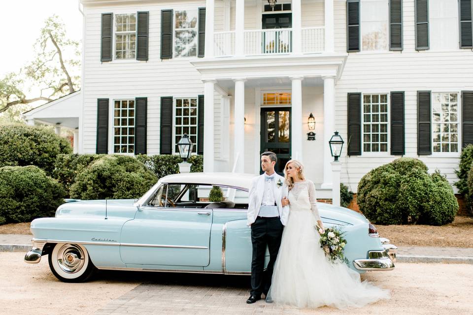 Newlyweds by their car