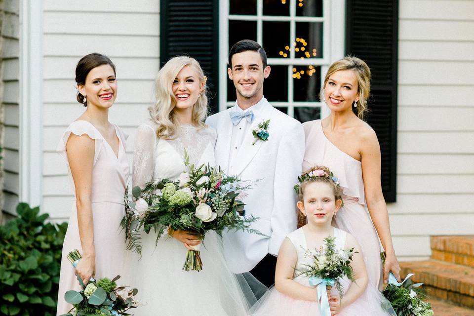 Newlyweds with the bridesmaids and flower girl