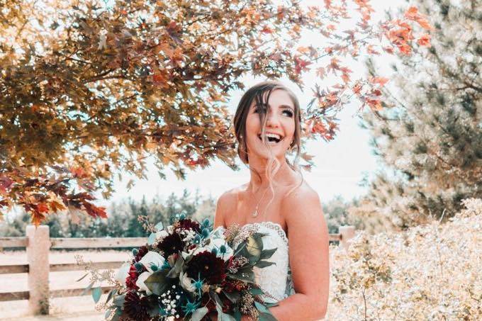 Bride standing under fall leaves