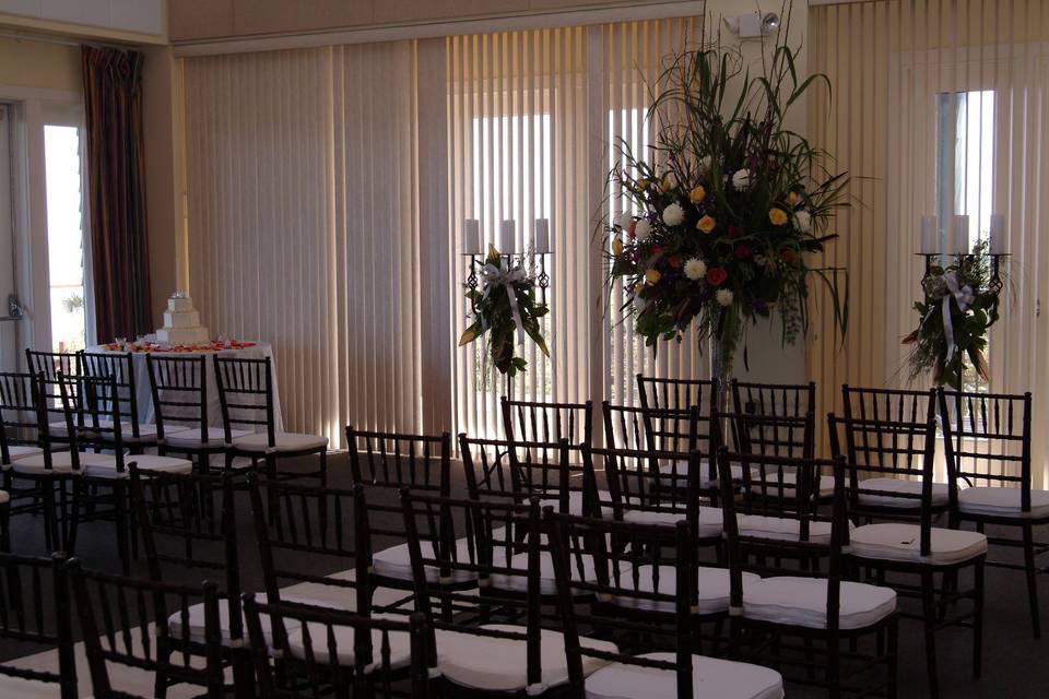 Chiavari chairs with white cushions, light fabric draping.