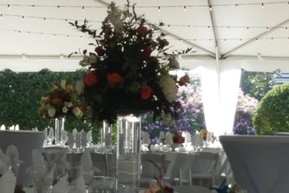 Beautiful arrangement in tented reception by Perfect Day Florist