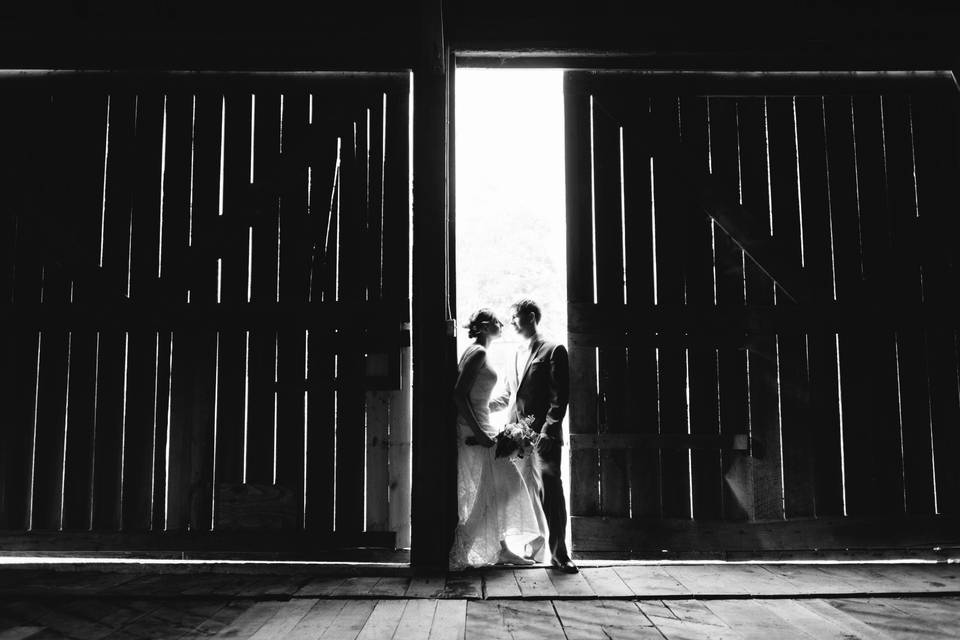 Sharing a private moment by the rustic barn doors