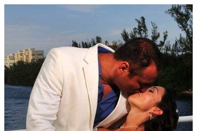 Groom dipping bride and kissing while aboard a beautiful yacht