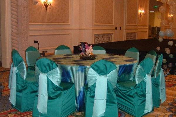 Aqua blue satin chair covers and ocean waves table covers.