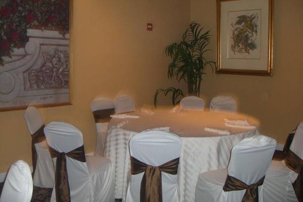 White satin stripe chair and table covers with brown satin bows.