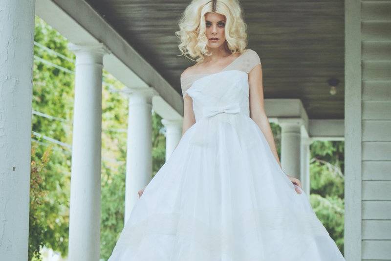 Style: 11007TRELLIS Tea-length dress in organza with striped, elastic trim throughout bodice and skirt. Organza bow at waist. Available in white only. 100% silk.