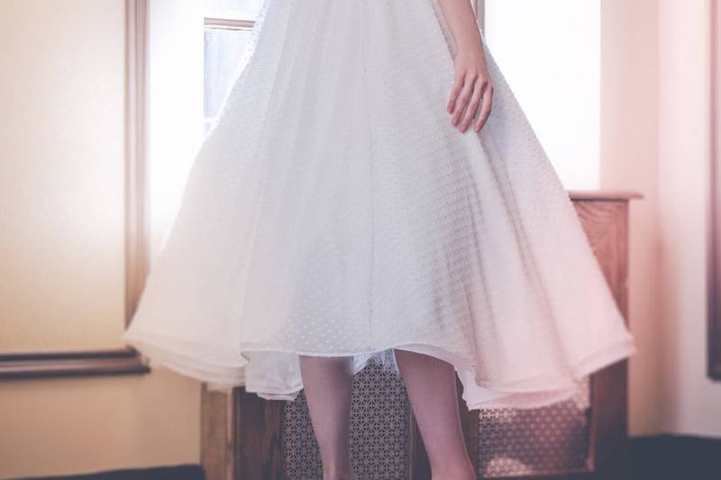 Style: 11001Back- CAMELIA Tea-length dress in dotted swiss with illusion neckline and cap sleeves. Keyhole at back. Available in white or ivory. 100% silk.