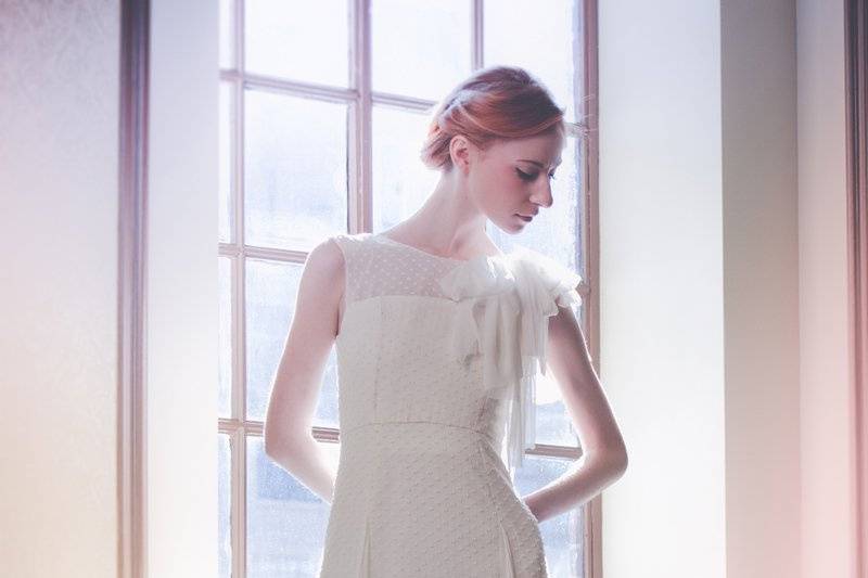 Style: 11004LIERRE Full-length gown in dotted swiss with illusion neckline and cap sleeves. Silk tulle bows at shoulder and scarves throughout skirt. Available in white or ivory. 100% silk.