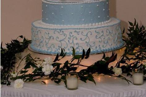 Light blue and white 4 tier cake with topper in the middle