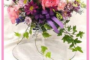 Bridal bouquet in pink, purple, & white mix of blooms arranged in a crystal goblet.