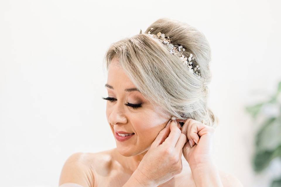 Bride putting on earrings