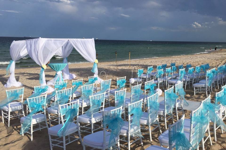 Beach wedding set up. White chiavari chairs and Chuppah.