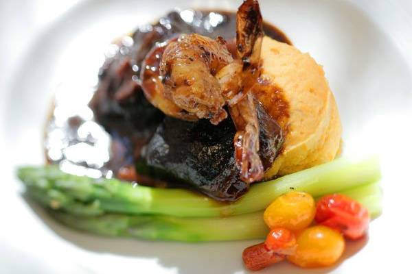 duo of shrimp and braised short ribs with Bourbon sauce, steamed asparagus, marinated cherry tomatoes and cheese mashed potatoes