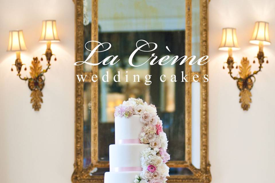 This elegant five tier wedding cake is accented with a beautiful fresh flower cascade and soft pink ribbons.