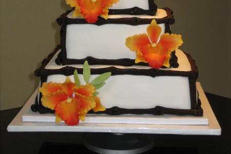 This Hawaiian Style fondant wedding cake was specially made for  a very sweet couple, Cassandra and Steve,The event took place at the New Port Dunes.It is a vanilla cake with 2 fillings, mango mousse and french custard with mango chunks.