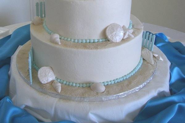 3-tier wedding cake with blue fences and chairs