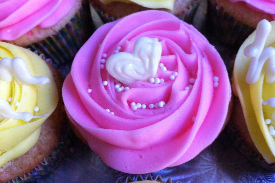 Stay Sweet Cupcakes - Pink - Sweet white almond cake with pink batter bits, topped with almond buttercream, Yellow: Fresh lemon cake with lemon buttercream. Topped with white chocolate accents