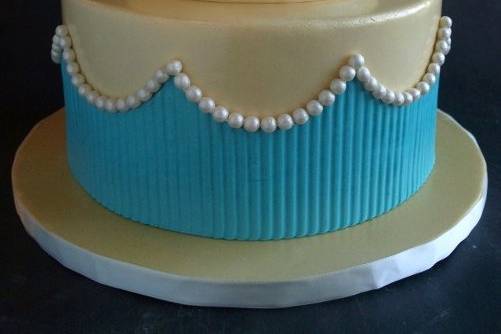 Two tier fondant covered cake with pearls, vibrant blue wrap