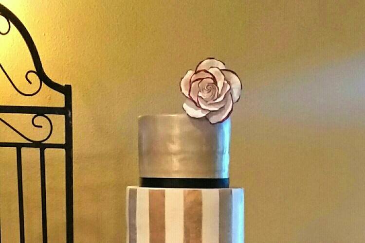 5-tier fondant covered wedding cake.  Custom colored champagne airbrushed onto tiers.  Edible lace on bottom tier.  Gum Paste flowers tipped in red to match bride's decor.