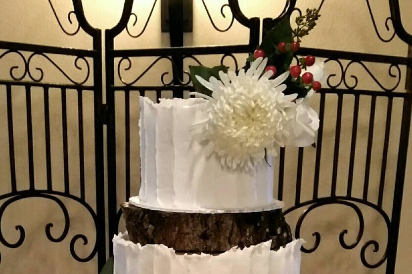 4-tier butter cream rustic wedding cake with fresh flowers.  Cake tiers are separated with real tree slices.  Bottom tree slice we had personalized for the bride and groom to keep.