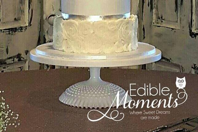 Combination of fondant and butter cream design.  Focal tier has lace applique design with Swarvoski crystals and pearls.  Silver leaf ribbon.  Gum Paste flowers tipped in silver.