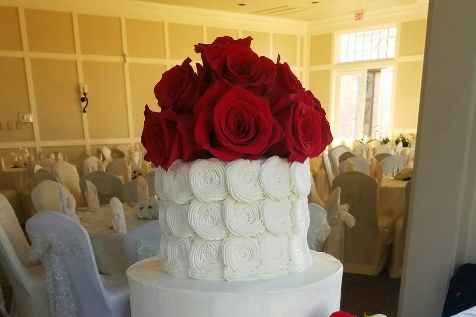 A butter cream beauty with rosettes and fresh red roses
