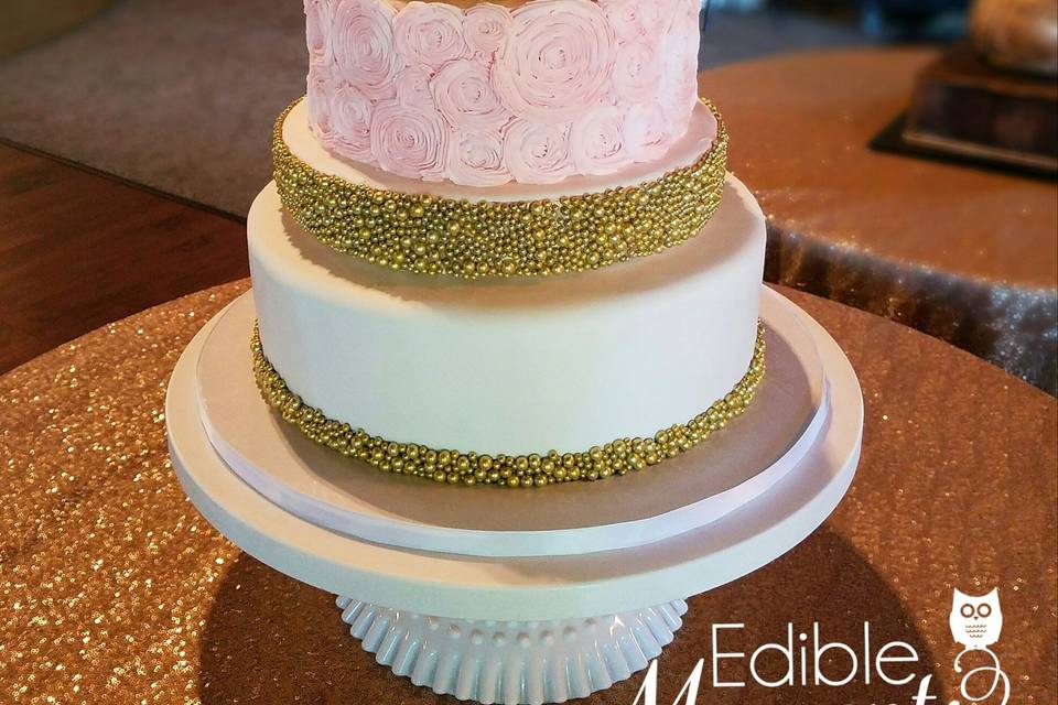 A beautiful combination of fondant and butter cream design.  Focal gold tier.  Butter cream rosettes.  Fresh flowers.