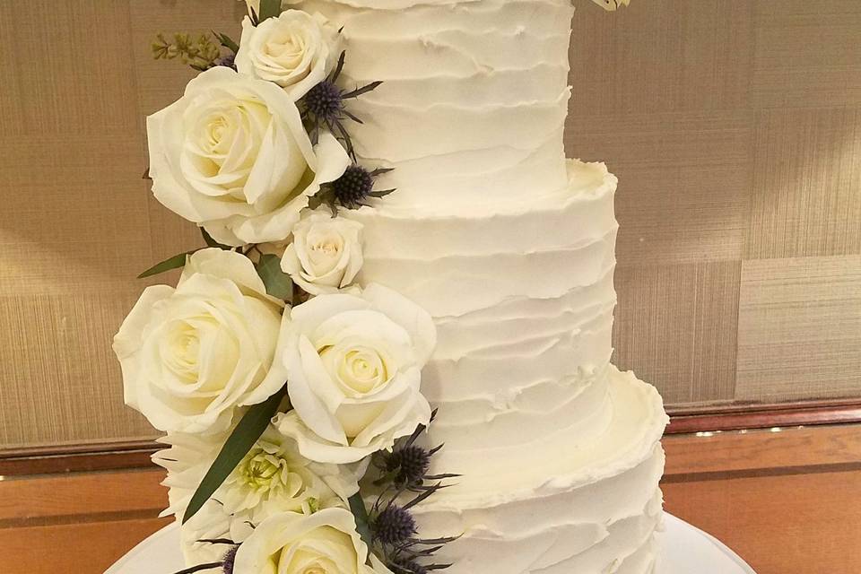 4-tier Art Deco themed wedding cake.  Flower tipped in gold.  6-inch height black focal tier with intricate pattern.  Matching pattern on bottom tier, tone on tone in pearl sheen.