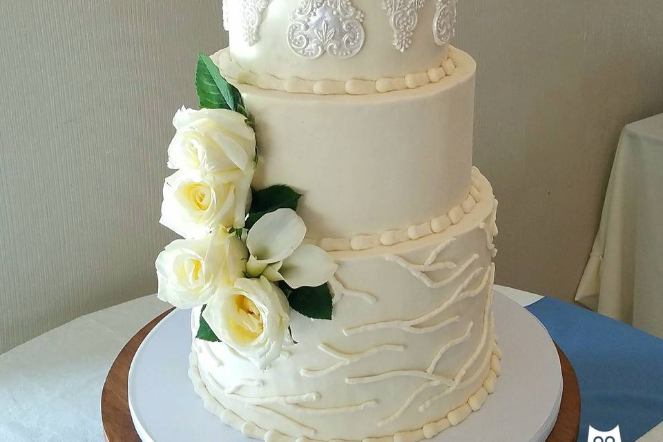 5-tier fondant covered wedding cake.  Custom colored champagne airbrushed onto tiers.  Edible lace on bottom tier.  Gum Paste flowers tipped in red to match bride's decor.