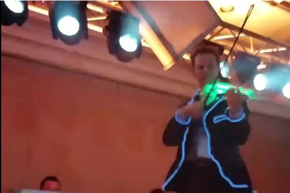 Electric led violinist performs as a dj violinist at a wedding with dmx controlled moving heads, dj booth, deejay and lighting crew, vertical and horizontal trussing.