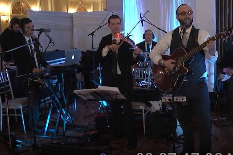 Our wedding band at reception with guitar, singers, electric violin, bass, drums, percussion, saxophone, trumpet, sound company and stage lighting.