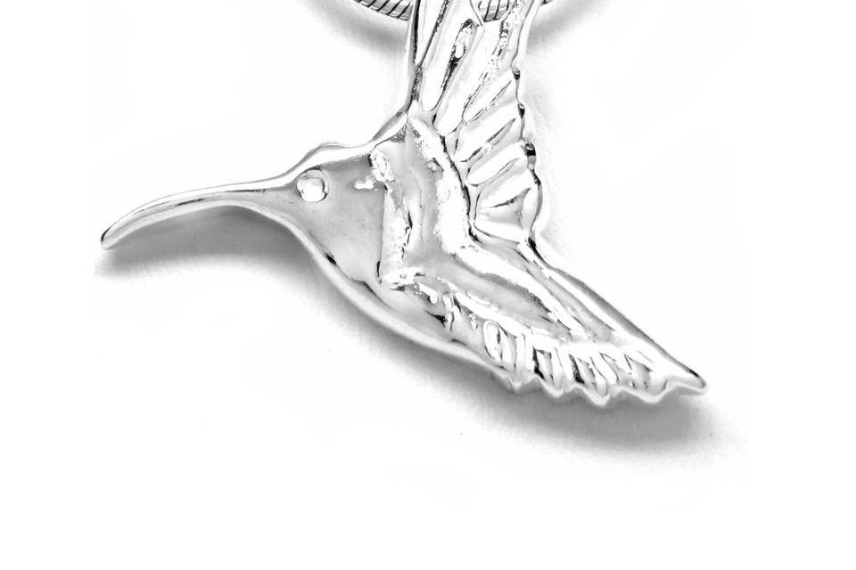 Sterling Silver hummingbird necklace is delicate, feminine and festive. It measures 1 1/2 inches wide by 1 1/4 inches high. The hummingbird is suspended with a ring on reverse and showcased on an 18-inch Sterling silver snake chain with a lobster-ring clasp. Symbolism: The hummingbird symbolizes joy and playfulness as well as independence. It has the characteristics of being well traveled, displaying resiliency by covering great distances tirelessly. It reminds us to enjoy the simple pleasures and to experience the sweet nectar of life.