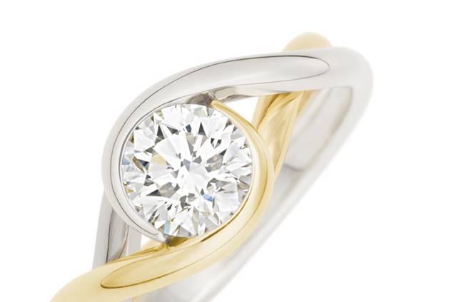 Two strands of precious metal intertwine, symbolic of your love and life together, and embrace a sparkling diamond, sapphire, emerald, ruby or tourmaline.Beautifully simple, yet complex, with ‘one-of-a-kind’ possibilities. This two-tone Embrace Ring features a 1.14ct round diamond in 18k yellow gold and platinum. #030404