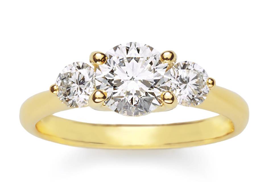 Always a classic, this 18K yellow gold ring cradles three colorless round brilliant diamonds, for the woman who wants simplicity with tons of sparkle.