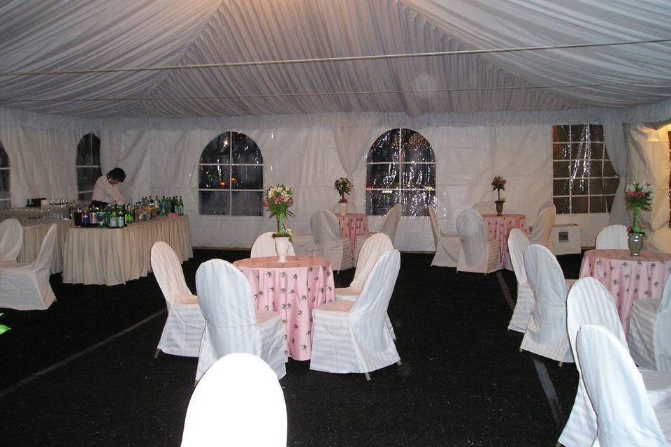 Draped ceiling, window sidewalls, white chair covers, chandelier lighting
