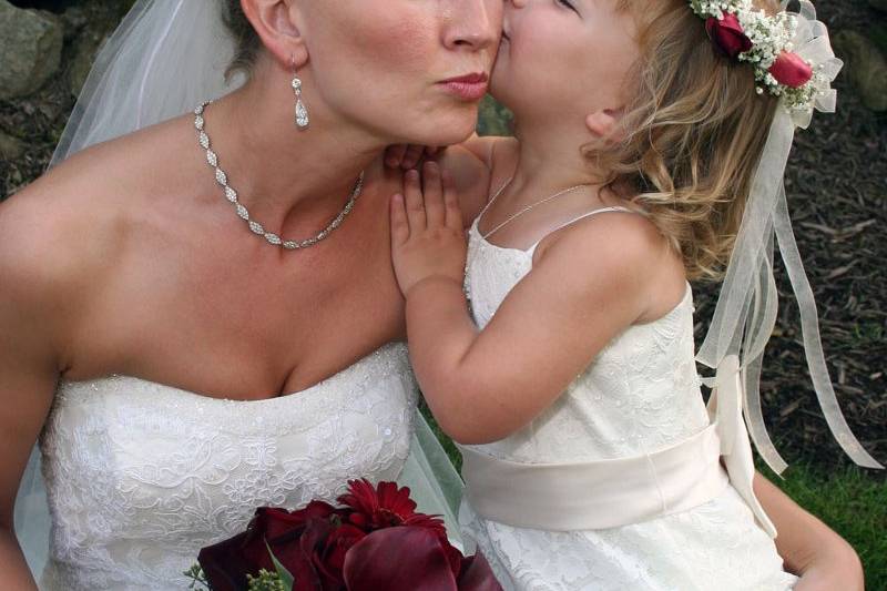 Flower girl kisses the bride