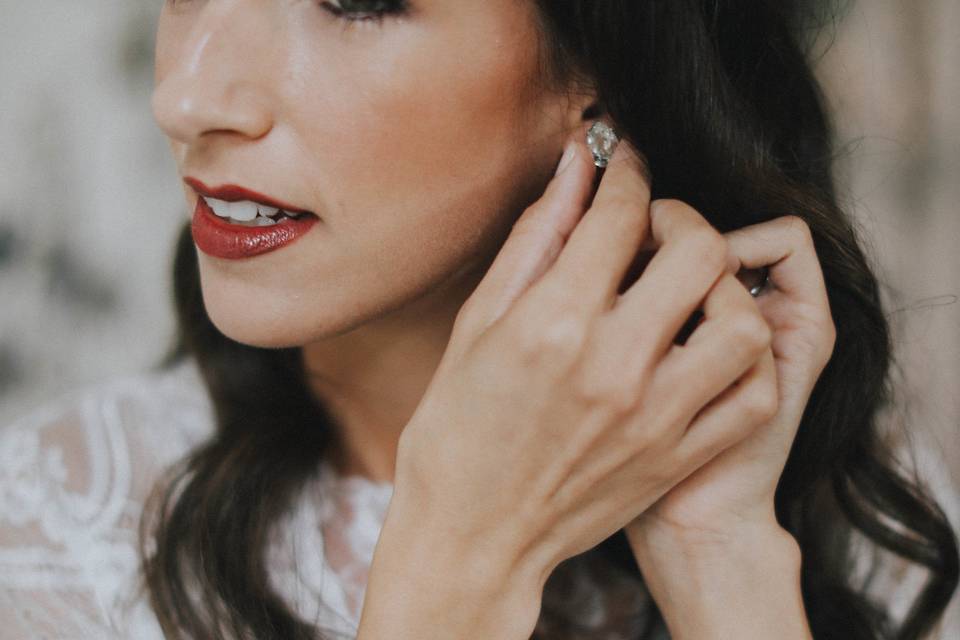 Bride putting earrings on