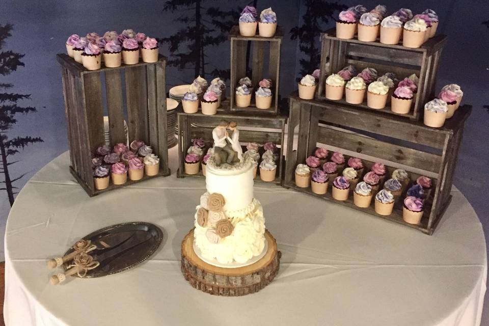 Wedding cake with cupcakes behind it