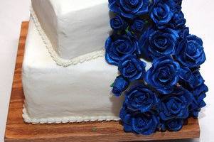 Midnight blues sugar roses cascade down the three tier square cake.