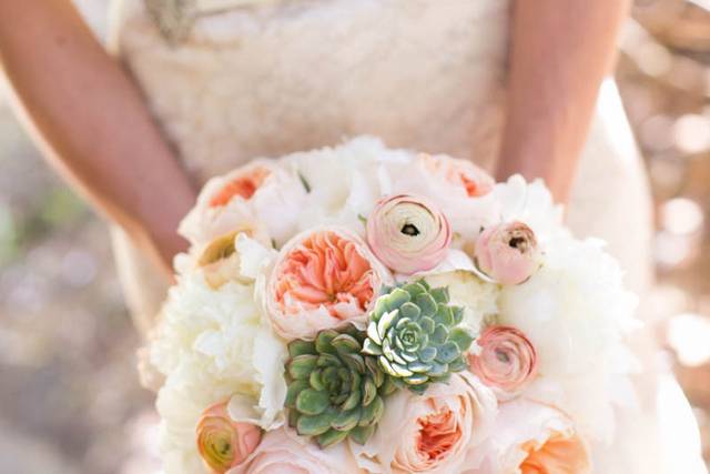 Romantic bridal bouquet with peach garden roses, succulents ranunculus and peony