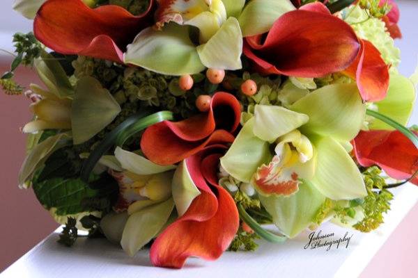 Green orchids and orange calla lilies for a dramatic summer bouquet